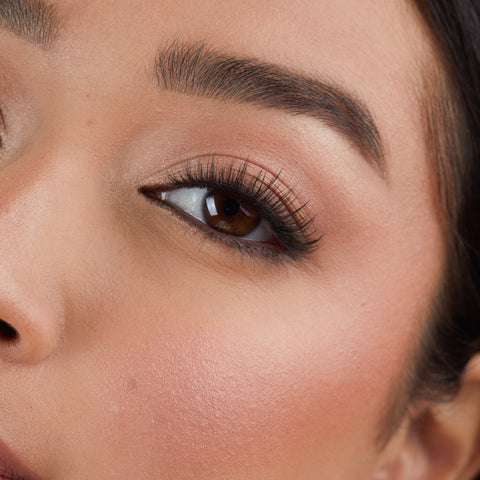 Lithe Lashes Core Collection lash style named 05 Wispy and Willowy, an image of a model’s face wearing lithe lashes on both eyes, with full makeup, looking from a left side profile, semi zoomed in, displaying the elegance of the lashes on her eyes.