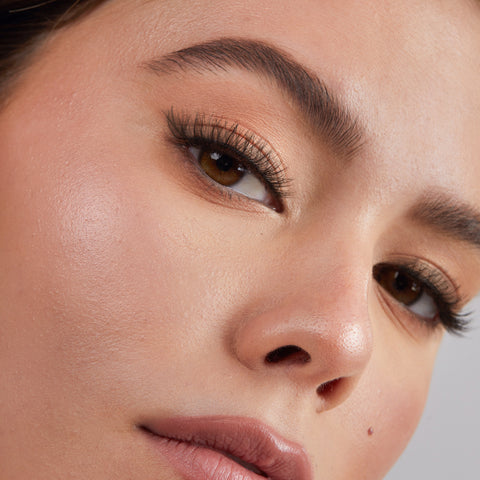 Lithe Lashes Core Collection lash style named 08 Criss Crossed and Winged, an image of a model’s face wearing lithe lashes on both eyes, with full makeup, looking from a right side profile, semi zoomed in, displaying the elegance of the lashes on her eyes.