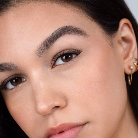 Lithe Lashes, Nude Collection, N1 Minimally Winged, an image of a model’s face wearing lithe lashes on both eyes, with full makeup, looking from a left side profile, semi zoomed in, displaying the elegance of the lashes on her eyes.