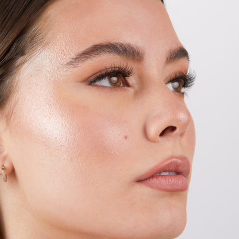 Lithe Lashes Core Collection lash style named 02 Everyday Round, an image of a model’s face wearing lithe lashes on both eyes, with full makeup, looking from a right side profile, semi zoomed in, displaying the elegance of the lashes on her eyes.