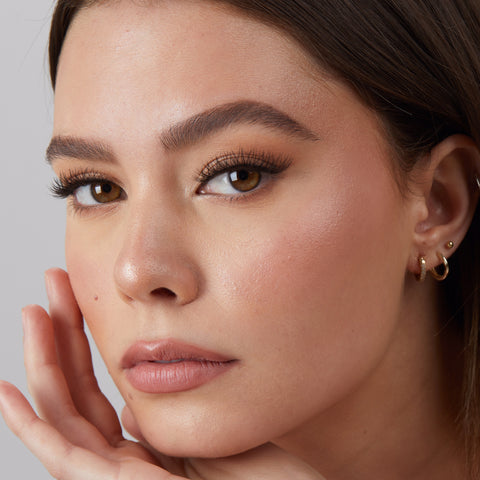 Lithe Lashes Core Collection lash style named 08 Criss Crossed and Winged, an image of a model’s face wearing lithe lashes on both eyes, with full makeup, looking from a left side profile, semi zoomed in, displaying the elegance of the lashes on her eyes.