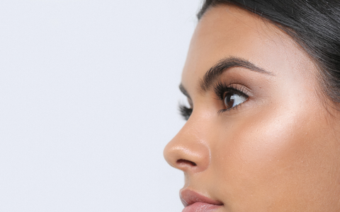 pair of Lithe Lashes in grey biodegradable tray and white FSC Certified paper box, on a silky background of light flowing brown and beige fabric 