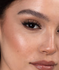 Lithe Lashes Bold Collection Style B6 - Prim & Pleated, an image of a model’s face wearing lithe lashes on both eyes, with full makeup, looking from a right side profile, semi zoomed in, displaying the elegance of the lashes on her eyes.