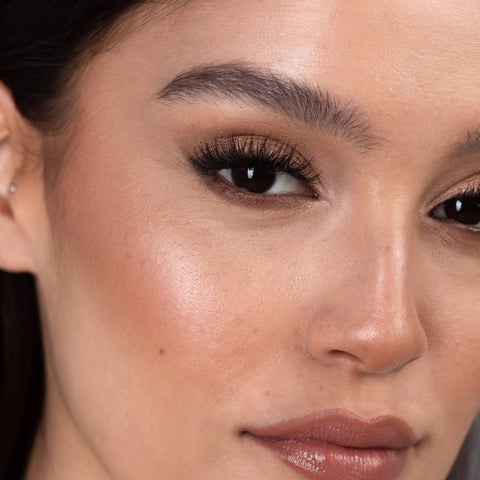 Lithe Lashes Bold Collection Style B6 - Prim & Pleated, an image of a model’s face wearing lithe lashes on both eyes, with full makeup, looking from a right side profile, semi zoomed in, displaying the elegance of the lashes on her eyes.