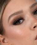 Lithe Lashes Bold Collection Style B3 - Kabuki, an image of a model’s face wearing lithe lashes on both eyes, with full makeup, looking from a right side profile, semi zoomed in, displaying the elegance of the lashes on her eyes.